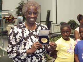 FILE - In a Tuesday, July 25, 2006 file photo, Unita Blackwell, left, the first black woman mayor in the state of Mississippi, shows an audience the gold minted coin given to her in recognition of her pioneering struggles for voters rights, in Greenville, Miss. Unita Blackwell, a civil rights activist who was the first African American woman to win a mayor's race in Mississippi , died Monday, May 13, 2019  in Ocean Springs Hospital. She was 86.