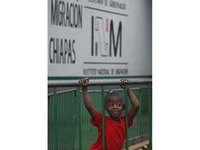 A Haitian child plays on a crowd control barrier at an immigration detention center where migrants had camped for weeks awaiting word on requests for asylum or permits that would allow them to continue north, in Tapachula, Mexico, Wednesday, May 29, 2019. Mexican immigration authorities cleared a park of camping Central American migrants and the makeshift encampment of Haitians and African migrants outside the immigration detention center near the Guatemala border.