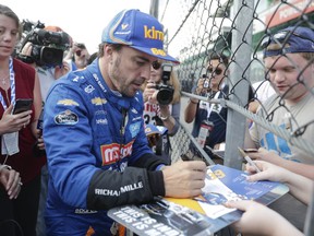 Fernando Alonso, of Spain, stops to sign autographs after qualifications ended for the Indianapolis 500 IndyCar auto race at Indianapolis Motor Speedway, Saturday, May 18, 2019, in Indianapolis.