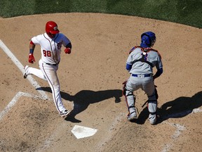 Washington Nationals' Gerardo Parra, left, scores on Kurt Suzuki's single in front of New York Mets catcher Tomas Nido in the seventh inning of a baseball game, Thursday, May 16, 2019, in Washington. Washington won 7-6.