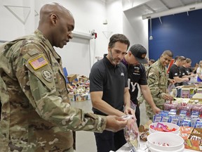 NASCAR driver Jimmie Johnson, second from left, helps assemble care packages for the North Carolina USO during a news conference in Concord, N.C., Tuesday, May 14, 2019.
