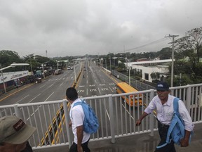 Men walk across a road with low circulation due to a general strike called by the opposition to Nicaraguan President Daniel Ortega in Managua, Nicaragua, Thursday, May 23, 2019. The nation-wide strike was called to pressure the government to free political prisoners.