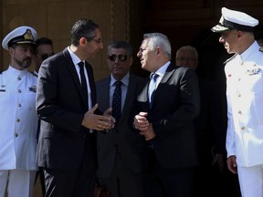 Cyprus' defense Minister Savvas Angelides, second left, talks with his Greek counterpart Evaggelos Apostolakis after their meeting with Cyprus' president Nicos Anastasiades at the presidential palace in Nicosia, Cyprus, Wednesday, May 8, 2019. Cyprus says it will rally support from fellow European Union countries and others to counter Turkey's bid to drill in waters where the east Mediterranean island nation has exclusive economic rights.