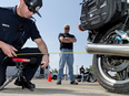 An Edmonton police officer tests the sound level of a motorcycle during a voluntary decibel check in 2010. The city has had a long fight against excessive vehicle noise.