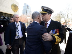 Liberal MP Andrew Leslie hugs Vice Admiral Mark Norman as he arrives to court in Ottawa on Wednesday, May 8, 2019.