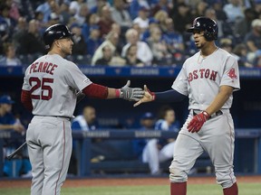 Boston Red Sox's Xander Bogaerts, right, celebrates his scored run with teammate Steve Pearce (25) during sixth inning American League MLB baseball action in Toronto on Thursday, May 23, 2019.