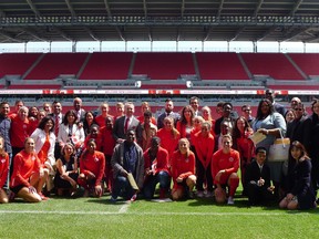 Members of the Canadian women's national soccer team pose alongside newly sworn-in Canadians after a special citizenship ceremony at BMO Field in Toronto on Friday, May 17, 2019.