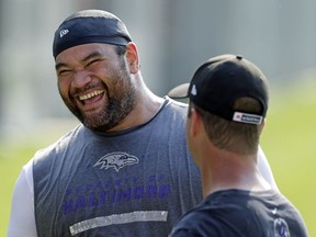 FILE - In this June 17, 2014, file photo, Baltimore Ravens nose tackle Haloti Ngata, left, laughs as he chats with head coach John Harbaugh after an NFL football practice, in Owings Mills, Md. Ngata came into the NFL with Baltimore and will leave as a member of the Ravens, the team that provided him with his best memories and a Super Bowl ring.