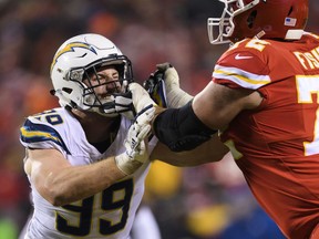 FILE - In this Dec. 13, 2018, file photo, Los Angeles Chargers defensive end Joey Bosa (99) tries to get past Kansas City Chiefs offensive tackle Eric Fisher (72) during an NFL football game in Kansas City, Mo. Bosa is hoping to return to form with the Chargers wearing a new yet familiar number. The defensive end has switched from No. 99 to 97. Bosa wore that number at St. Thomas Aquinas High School in Fort Lauderdale, Florida, and at Ohio State. It is also a significant number for the Bosa family. John Bosa wore No. 97 for three seasons in the NFL and Nick Bosa, Joey's younger brother, will wear it for San Francisco after being the second overall pick in the April draft.