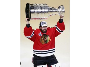 FILE - In this June 10, 2015, file photo, Chicago Blackhawks' goalie Corey Crawford hoists the Stanley Cup trophy after defeating the Tampa Bay Lightning in Game 6 of the NHL hockey Stanley Cup Final series, in Chicago. Two-time Stanley Cup champion goaltender Corey Crawford will drive the pace car for Saturday's IndyCar Grand Prix. Race organizers said Tuesday, May 7, 2019, that Crawford will drive a Chevrolet Corvette Grand Sport Coupe on Indianapolis Motor Speedway's 14-turn, 2.439-mile road course.