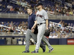 FILE - In this May 1, 2019, file photo, Cleveland Indians starting pitcher Corey Kluber, right, leaves during the fifth inning of the team's baseball game against the Miami Marlins, in Miami. Kluber was hit by a single hit by Marlins' Brian Anderson. Kluber is hopeful he'll be able to come back from a broken right arm and pitch again this season.  The two-time Cy Young winner spoke Tuesday, May 7 for the first time since he was struck by a 102 mph line drive last weeki.