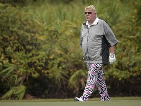 FILE - In this Dec. 15, 2018, file photo John Daly walks on the ninth green during the first round of the Father Son Challenge golf tournament in Orlando, Fla. The PGA Championship is allowing Daly to use a cart next week at Bethpage Black. It will be the first time since Casey Martin in the U.S. Open in 2012 that a player is allowed to ride a cart during a major.