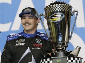 FILE - In this Nov. 16, 2018, file photo, Brett Moffitt stands with his trophy in Victory Lane after winning the NASCAR Truck Series auto racing season championship, at Homestead-Miami Speedway in Homestead, Fla. After winning a NASCAR Truck series title in 2018, Moffitt is still searching for his first win this season.