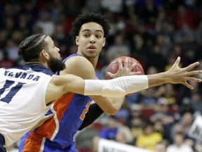 FILE - In this Thursday, March 21, 2019 file photo, Florida's Andrew Nembhard, right, is defended by Nevada's Cody Martin (11) during the second half of a first round men's college basketball game in the NCAA Tournament in Des Moines, Iowa. Florida point guard Andrew Nembhard is returning to school for his sophomore year, a move that should have a positive impact on the Gators next season. Nembhard announced his decision on social media Wednesday, hours before the deadline to withdraw from the NBA draft.