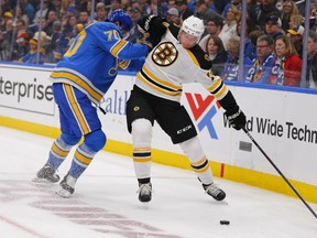 FILE - In this Feb. 23, 2019, file photo, Boston Bruins' Charlie Coyle (13) tries to avoid a check from St. Louis Blues' Oskar Sundqvist (70), of Sweden, during the first period of an NHL hockey game in St. Louis. Game 1 of the Stanley Cup finals between the Bruins and Blues is Monday, May 27.