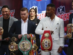 FILE - In this March 1, 2019, file photo, WBC and WBA middleweight world champion Canelo Alvarez, second from left, and IBF middleweight world champion Daniel Jacobs, second from right,  pose with their title belts during a press conference in Mexico City. The moment won't be too big for Daniel Jacobs, of that he's certain. Not after going toe-to-toe with the fearsome Gennady Golovkin before dropping a narrow decision. Not after beating cancer that doctors were sure would end his career, if not his life. Canelo Alvarez will just be another obstacle in front of him when they meet Saturday night, May 4 in a middleweight title unification fight.