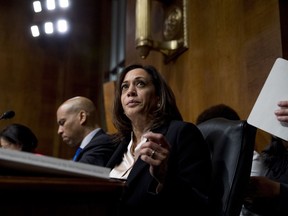 FILE - In a Wednesday, May 1, 2019 file photo, Democratic presidential candidates Sen. Cory Booker, D-N.J., left, and Sen. Kamala Harris, D-Calif., center, listen as Attorney General William Barr testifies during a Senate Judiciary Committee hearing on Capitol Hill in Washington, on the Mueller Report. The Democrats who want to be president are swarming California, competing for campaign cash and media attention while courting longtime allies of home-state Sen. Kamala Harris on their rival's own turf.