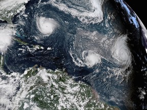 This Sept. 11, 2018 enhanced satellite image made available by NOAA shows Tropical Storm Florence, upper left, in the Atlantic Ocean, Tropical Storm Isaac, center, and at right Hurricane Helene. On Thursday, May 23, 2019, The National Oceanic and Atmospheric Administration says the Atlantic hurricane season should be near normal. NOAA predicted nine to 15 named storms. It says four to eight of them will become hurricanes and two to four of those major hurricanes with 111 mph winds or higher. (NOAA via AP)
