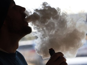 FILE - In this Friday, Jan. 18, 2019 file photo, a customer blows a cloud of smoke from a vape pipe at a local shop in Richmond, Va. Although e-cigarettes aren't considered as risky as regular cigarettes, new research published Monday, May 27, 2019, finds a clue that their flavorings may be bad for the heart.