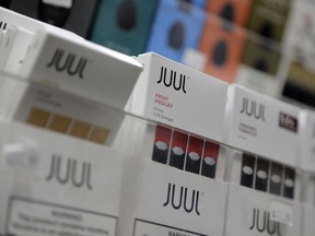 FILE - In this Dec. 20, 2018, file photo Juul products are displayed at a smoke shop in New York. Under scrutiny amid a wave of underage vaping, Juul is pushing into television with a multimillion-dollar campaign rebranding itself as a stop-smoking aid for adults trying to kick cigarettes.
