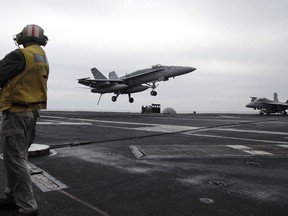 FILE - In this Feb. 13, 2012, file photo, a U.S. fighter jet lands on the USS Abraham Lincoln aircraft carrier during exercises in the Persian Gulf. The U.S. is dispatching the USS Abraham Lincoln and other military resources to the Middle East following "clear indications" that Iran and its proxy forces were preparing to possibly attack U.S. forces in the region, according to a defense official on May 5, 2019.