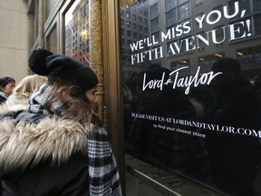 FILE - In this Jan. 2, 2019, file photo women peer in the front door of Lord & Taylor's flagship Fifth Avenue store which closed in New York. Lord & Taylor, one of the country's oldest department stores, may be sold as its owner considers its options. Hudson's Bay Co., which also owns Saks Fifth Avenue, says it hired a financial adviser to review Lord & Taylor's business and that the process may lead to a sale or merger.