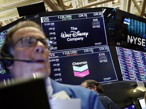 FILE - In this April 12, 2019, file photo the logos for The Walt Disney Company and Chevron appear above a trading post on the floor of the New York Stock Exchange. The Walt Disney Company reports financial results Wednesday, May 8.