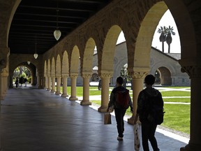 FILE - In this March 14, 2019, file photo, people walk on the Stanford University campus in Santa Clara, Calif. Financial aid award letters are known to be tricky to understand due to jargon and a lack of clarity about how much you have to pay out of pocket. If you can't interpret your financial aid award, you won't be able to compare letters from different schools.