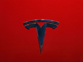 FILE- This Oct. 3, 2018, file photo shows the logo of Tesla model 3 at the Auto show in Paris. The National Transportation Safety Board says Tesla's Autopilot semi-autonomous driving system was in use when one of its cars drove beneath a semitrailer in Florida in March, killing the driver.