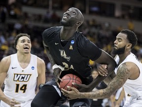 FILE- In this March 22, 2019 file photo, Central Florida center Tacko Fall (24) is fouled by VCU guard Mike'L Simms, right, during the second half of a first-round game in the NCAA men's college basketball tournament in Columbia, S.C. The NBA has picked 11 players from the G League Elite Camp to stay for the NBA draft combine that starts Thursday, May 16. Fall, Florida State's Terance Mann, Miami's Dewan Hernandez, Syracuse's Oshae Brissett, Nevada's Cody Martin, Tulsa's DaQuan Jeffries, Auburn's Jared Harper, Iowa's Tyler Cook, Iowa State's Marial Shayok, Mississippi State's Reggie Perry and Ole Miss' Terence Davis were invited Wednesday, May 15 to stay.