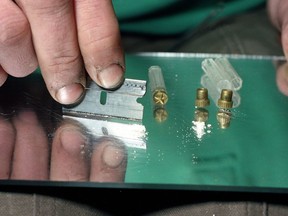 FILE - In this 1989 file photo, a razor blade is used to divide the contents of a five-dollar vile of crack, a smokable, purified form of cocaine, at a crack house in the South Bronx section of New York. Cocaine deaths have been rising, health officials said Thursday, May 2, 2019, in their latest report on the nation's drug overdose epidemic. After several years of decline, overdose deaths involving cocaine began rising in 2013. And they jumped by more than a third between 2016 and 2017.