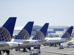 FILE - In this July 18, 2018, file photo, United Airlines commercial jets sit at a gate at Terminal C of Newark Liberty International Airport in Newark, N.J. United Airlines is canceling another month's worth of flights with Boeing 737 Max planes that were grounded after two deadly accidents. United said Friday, May 24, 2019,  it has removed the Max from its schedule through Aug. 3 and will cancel about 2,400 flights in June and July as a result. It had previously canceled all Max flights through early July.