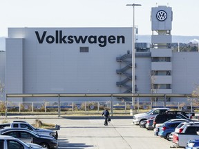 FILE - In this Dec. 4, 2015, file photo, a man walks through the employee parking lot at the Volkswagen plant in Chattanooga, Tenn. In a split decision, the National Labor Relations Board on Wednesday, May 22, 2019,  has ruled in favor of Volkswagen in a setback for unionization efforts at its Chattanooga, Tennessee, plant. The NRLB has dismissed a petition for a union vote by the United Auto Workers based on a technicality. The union intends to refile immediately.