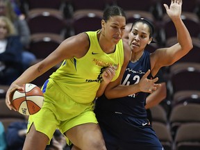 FILE - In this May 8, 2018, file photo, Dallas Wings' Liz Cambage, left, drives against Connecticut Sun's Brionna Jones during a preseason WNBA basketball game in Uncasville, Conn. A person familiar with the situation tells The Associated Press that the Dallas Wings have traded Liz Cambage to Las Vegas for Moriah Jefferson, Isabelle Harrison and the Aces' first two picks in 2020.  The person spoke on condition of anonymity Thursday, May 16, 2019, because the deal hasn't been announced.