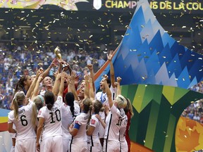 FILE - In this July 5, 2015 file photo, confetti floats down as the United States women's national team celebrate with the trophy after beating Japan 5-2 in the FIFA Women's World Cup soccer championship in Vancouver, British Columbia, Canada. When FIFA released its global strategy for women's soccer last year, it was met by some skepticism. But soccer's governing body is making some strides in implementing the long-range plan, against a backdrop of this summer's World Cup in France.