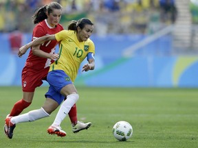 FILE - In this Aug. 19, 2016, file photo, Brazil's Marta, left, dribbles past Canada's Jessie Fleming during the bronze medal women' soccer match at the summer Olympic's at the Arena Corinthians stadium in Sao Paulo.