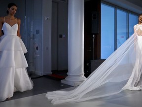 FILE - This April 12, 2019 file photo shows fashion from the Amsale bridal collection in New York. Bridal sites TheKnot.com, WeddingWire.com and Spanish-language Bodas.net released a report on wedding trends and traditions worldwide.