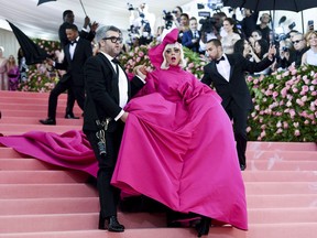 FILE - This May 6, 2019 file photo shows Lady Gaga, right, and designer Brandon Maxwell at The Metropolitan Museum of Art's Costume Institute benefit gala celebrating the opening of the "Camp: Notes on Fashion" exhibition in New York. Maxwell created the look that had her transitioning from a huge pink gown to black bra and panties, including glittery sky-high boots, at the May gala, considered fashion's biggest night.