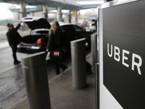 FILE - In this March 15, 2017, file photo, a sign marks a pick-up point for the Uber car service at LaGuardia Airport in New York. Drivers for ride-hailing giants Uber and Lyft are planning to turn off their apps to protest what they say are declining wages at a time when both companies are raking in billions of dollars from investors.