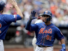 New York Mets' Carlos Gomez, right, is greeted by Steven Matz after scoring on a sacrifice fly by Juan Lagares during the fifth inning of a baseball game against the Washington Nationals, Thursday, May 23, 2019, in New York.