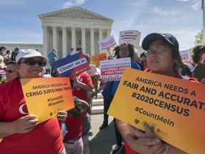 FILE - In this April 23, 2019 file photo, immigration activists rally outside the Supreme Court as the justices hear arguments over the Trump administration's plan to ask about citizenship on the 2020 census, in Washington. A new court filing Thursday, May 30 by lawyers opposing adding the citizenship question to the 2020 census alleges a longtime Republican redistricting expert played a key role in making the change.