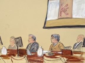 In this courtroom artist's sketch, Keith Raniere, second from right, leader of the secretive group NXIVM, attends his trial in Brooklyn federal court, Tuesday, May 7, 2019 in New York. Above him is a screen with an image of a branding, containing his initials KR. A federal prosecutor says the self-help guru used threats, "shame and humiliation" while grooming women for sex. She also described how some female followers were branded with Raniere's initials.