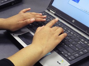 In this March 13, 2019, photo. a Bennett High School student re-images a laptop in a school computer lab in Buffalo, N.Y. The Buffalo district and others around the country are increasingly training students to help with the upkeep of thousands of laptops and iPads distributed to students in 1:1 initiatives that give students their own devices for the year.