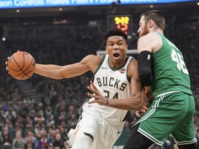 File-This May 8, 2019, file photo shows Milwaukee Bucks' Giannis Antetokounmpo driving past Boston Celtics' Aron Baynes during the first half of Game 5 of a second round NBA basketball playoff series in Milwaukee. Leading the Bucks' resurgence is MVP candidate Antetokounmpo, a fan favorite and a source of pride for Milwaukee's Greek community. Antetokounmpo was born in Athens, Greece."It's important for the Greek community to be able to gather together as a unit and celebrate him. And he in turn celebrates us," said Tim Stasinoulias, 61, a Bucks fan since the team came to Milwaukee in 1968.