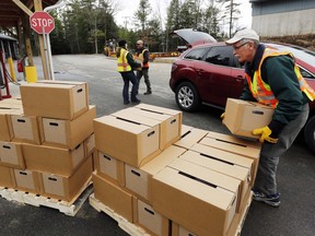 FILE - In this Monday, April 11, 2016 file photo, New Hampshire state and local officials load boxes of free bottled water in in Litchfield, N.H. New Hampshire is suing eight companies including 3M and Dupont for damage it says has been caused statewide by a class of potentially toxic chemicals found in everything from pizza boxes to fast-food wrappers. The state becomes the second in the nation to go after the makers of perfluoroalkyl and polyfluoroalkyl substances or PFAS and the first to target statewide contamination.