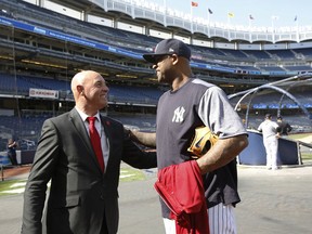 In this Wednesday, May 8, 2019 photo, former Liverpool goalkeeper Bruce Grobbelaar, left, speaks to New York Yankees pitcher CC Sabathia as the pair met on the field at Yankee Stadium in New York. When Grobbelaar celebrated at Anfield on April 28, 1990, he never thought it would be Liverpool's last league title in three decades.