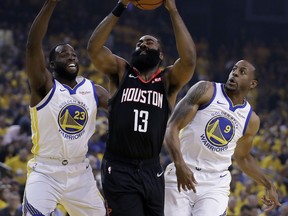 Houston Rockets' James Harden, center, looks to shoot between Golden State Warriors' Draymond Green, left, and Andre Iguodala (9) during the first half of Game 5 of a second-round NBA basketball playoff series Wednesday, May 8, 2019, in Oakland, Calif.