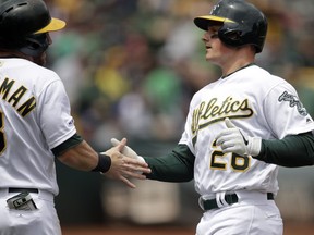 Oakland Athletics' Matt Chapman, right, is congratulated by Robbie Grossman (8) after hitting a two run home run off Seattle Mariners pitcher Mike Leake in the first inning of a baseball game Sunday, May 26, 2019, in Oakland, Calif.