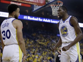 Golden State Warriors' Kevin Durant, right, speaks with Stephen Curry (30) after Curry was called for a foul during the first half of Game 5 of the team's second-round NBA basketball playoff series against the Houston Rockets on Wednesday, May 8, 2019, in Oakland, Calif.