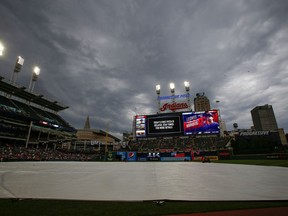 The tarp covers the infield as the the start of a baseball game between the Tampa Bay Rays at Cleveland Indians baseball game is being delayed, Saturday, May 25, 2019, in Cleveland.